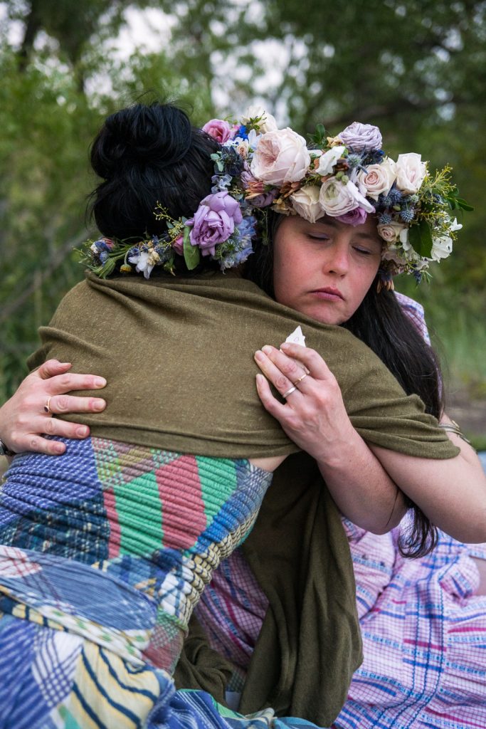Women hugging at a Colorado floral full moon party