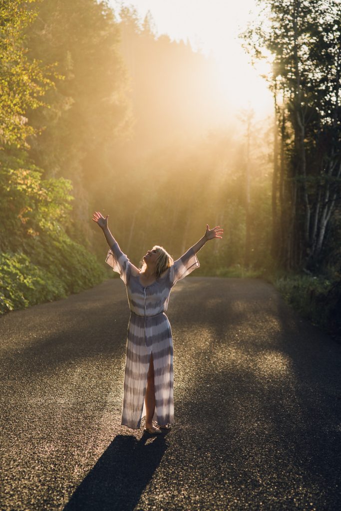 Melody with arms raised in golden light