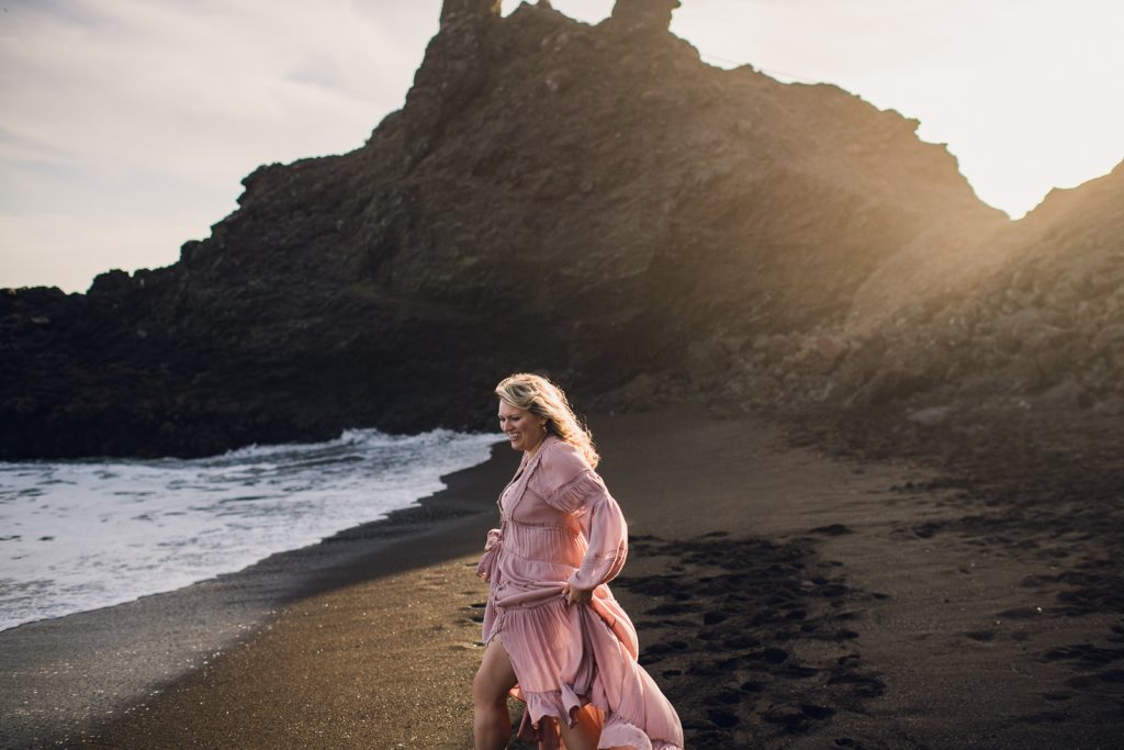 Melody laughing on a black sand beach